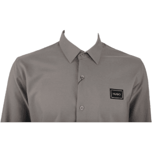 Close-up of HUGO Men's Slim-Fit Long-Sleeve Shirt in Grey, featuring logo patch and button details.