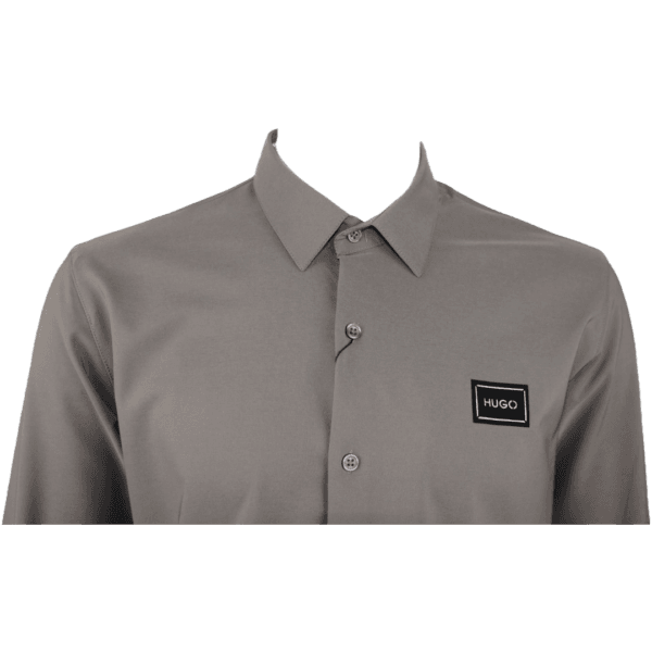 Close-up of HUGO Men's Slim-Fit Long-Sleeve Shirt in Grey, featuring logo patch and button details.