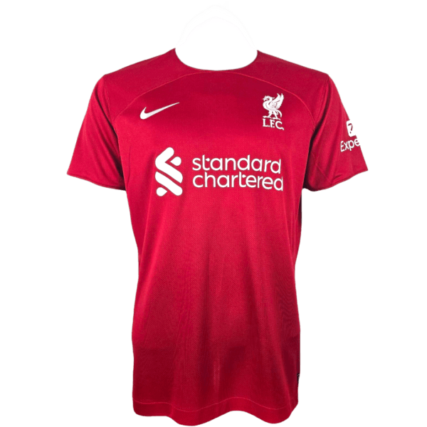 Liverpool FC Home Shirt in Red featuring LFC crest, Nike swoosh, and Standard Chartered sponsor logo.